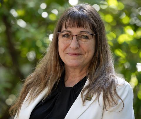 Dr. Jean Maltesen wearing a white business jacket, green background